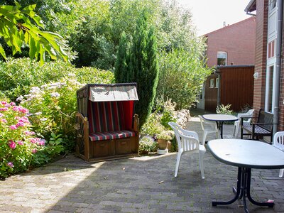 Ein Strandkorb und weitere Sitzgelegenheiten im Außenbereich der Einrichtung "Birkenhof"